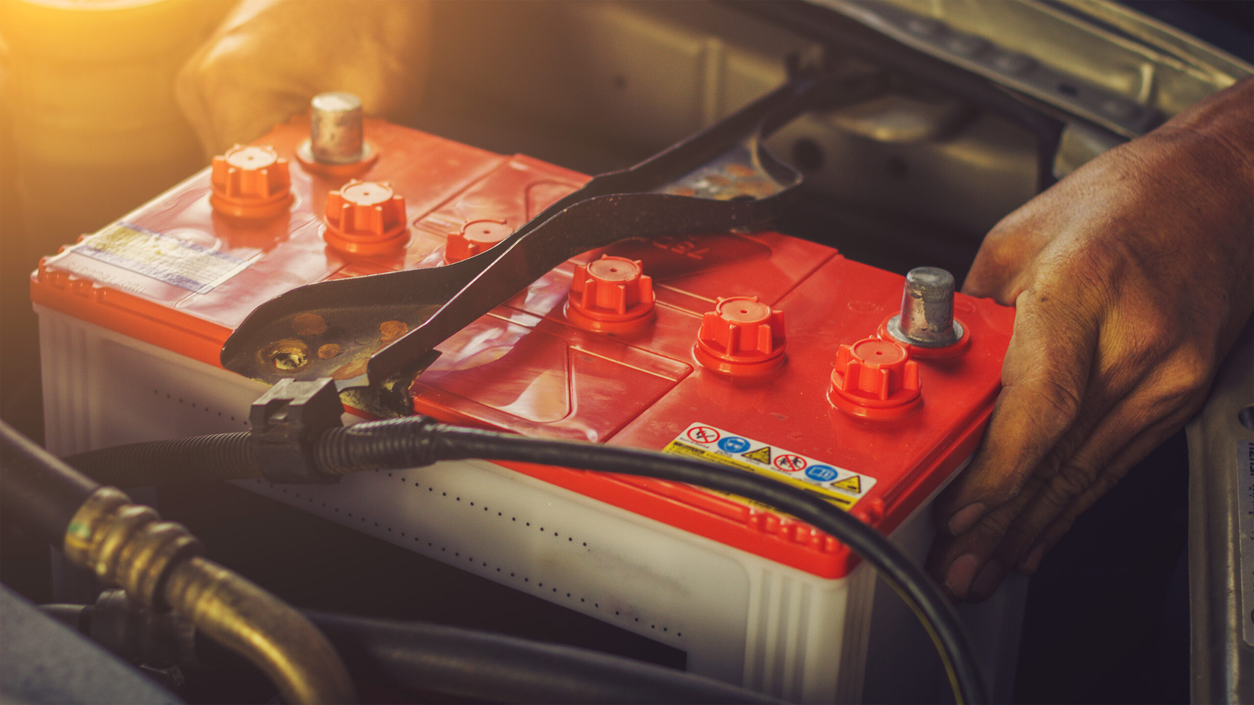 Image of a car mechanic replacing a car battery